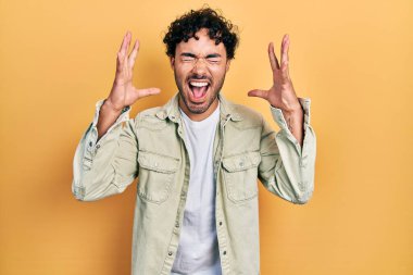 Gündelik kıyafetler giyen genç İspanyol adam başarı için deli ve çılgınlığı kutluyor kollarını kaldırmış ve gözlerini kapatmış heyecanla bağırıyor. Kazanan konsept 