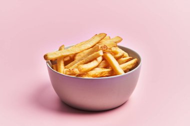  Bir kase kızarmış patates, pembe arka planda.
