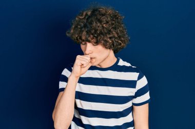 Handsome young man wearing casual striped t shirt feeling unwell and coughing as symptom for cold or bronchitis. health care concept. 