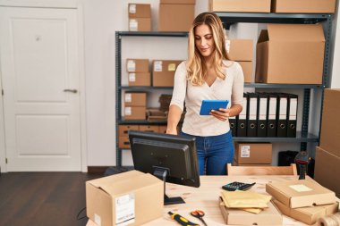 Ofiste çalışan genç sarışın iş kadını touchpad kullanıyor.