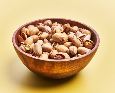  Sarı arka planda bir kase fıstık.
