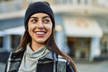 Genç İspanyol kadın gülümseyerek şehirde mutlu mesut dikiliyor..