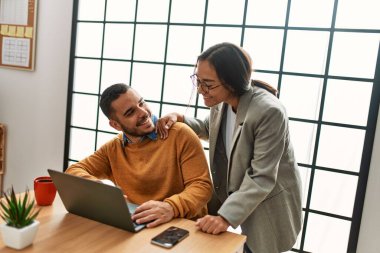 Ofiste masa başında çalışırken gülümseyen iki iş adamı..