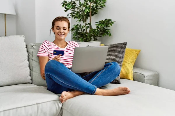Jovem Usando Laptop Cartão Crédito Sentado Sofá Casa — Fotografia de Stock