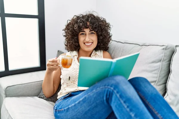 Mladý Střední Východ Žena Pije Čaj Čtení Knihy Doma — Stock fotografie
