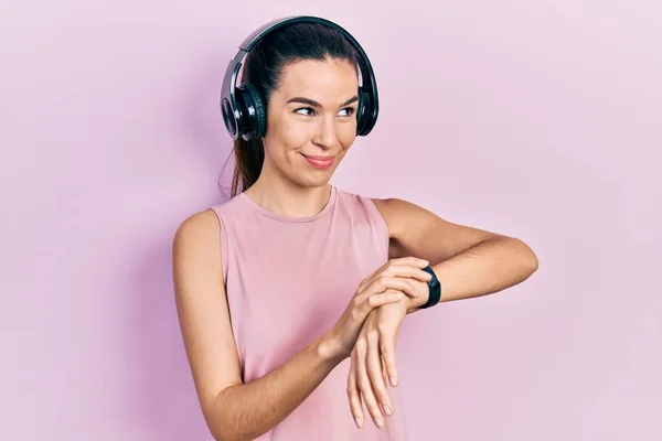 Young Brunette Woman Wearing Gym Clothes Using Headphones Smart Watch — Stockfoto