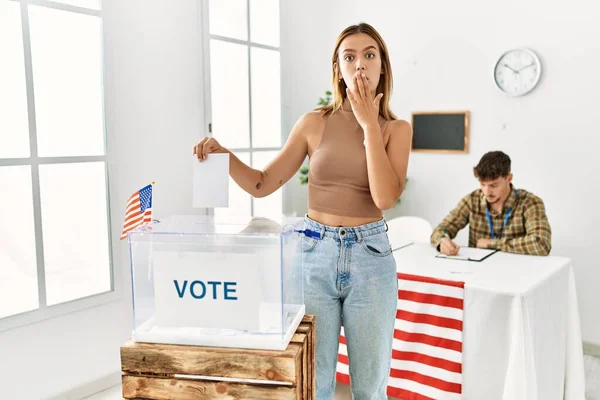 若いブロンドの女の子の投票は 手で口を覆う投票箱に包まれ ショックを受け 間違いを恐れています 驚きの表情 — ストック写真
