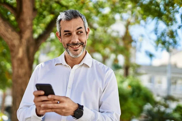 Středního Věku Šedovlasý Muž Úsměvem Šťastný Pomocí Smartphone Městě — Stock fotografie