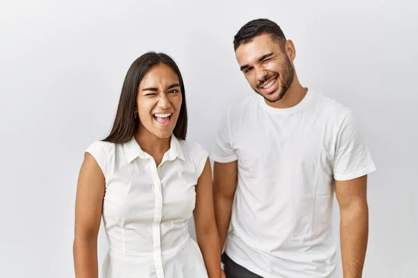 Young Interracial Couple Standing Together Love Isolated Background Winking Looking — Zdjęcie stockowe