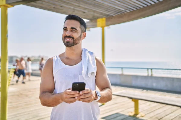 在阳光明媚的日子里 西班牙运动员在户外用智能手机锻炼 — 图库照片