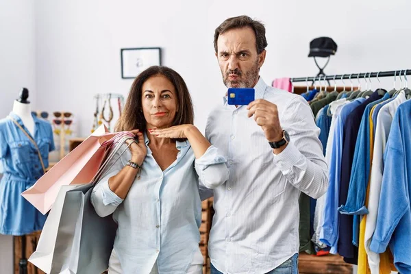 Hispanic Middle Age Couple Holding Shopping Bags Credit Card Cutting — Stockfoto