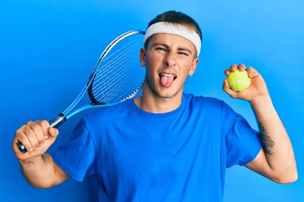 Jovem Caucasiano Jogando Tênis Segurando Raquete Bola Furando Língua Para — Fotografia de Stock