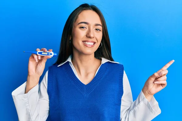 Menina Hispânica Jovem Segurando Termômetro Sorrindo Feliz Apontando Com Mão — Fotografia de Stock