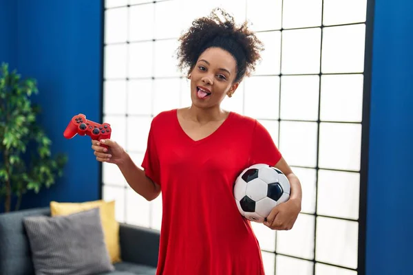 年轻的非洲裔美国女人玩足球电玩时 伸出舌头 带着滑稽的表情高兴极了 — 图库照片