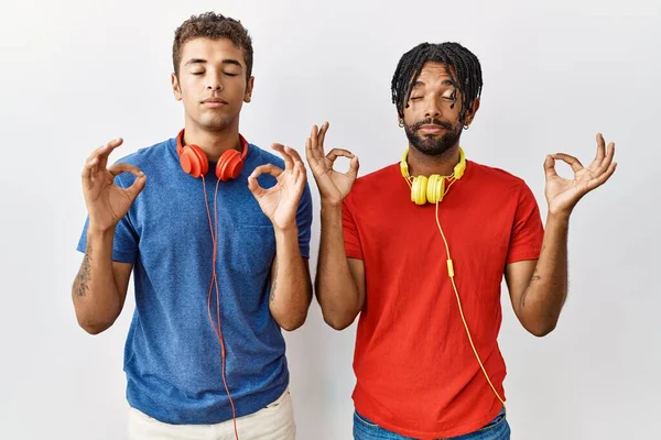 Молоді Іспаномовні Брати Стоять Над Ізольованим Фоном Носять Навушники Розслабляються — стокове фото