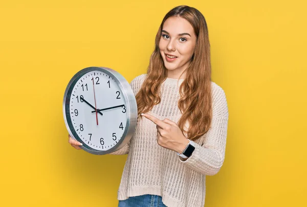 Joven Mujer Rubia Sosteniendo Gran Reloj Sonriendo Feliz Señalando Con —  Fotos de Stock