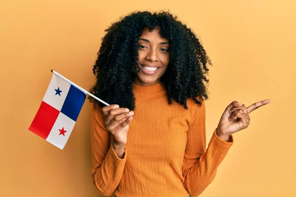 Африканская Американка Афроволосами Держащая Флаг Панамы Улыбается Показывая Рукой Пальцем — стоковое фото