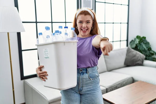 Jovem Ruiva Segurando Lixo Reciclável Com Garrafas Plástico Apontando Para — Fotografia de Stock