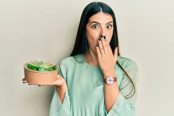 Young Hispanic Woman Eating Take Away Salad Covering Mouth Hand — ストック写真