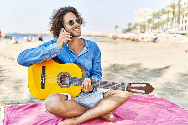 Ung Latinamerikan Man Spelar Gitarr Och Talar Smartphone Sitter Sand — Stockfoto