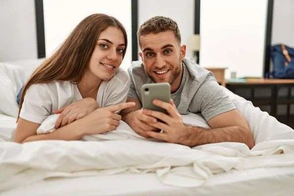 Jeune Couple Caucasien Utilisant Smartphone Couché Sur Lit Maison — Photo