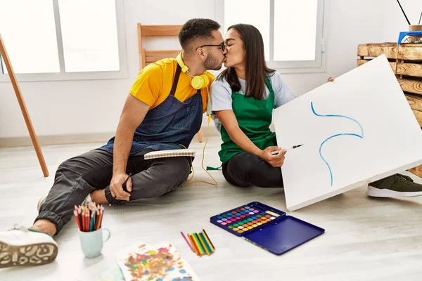 Young Hispanic Couple Kissing Drawing Sitting Floor Art Studio — Stockfoto