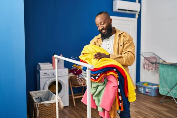 Ung Afrikansk Amerikansk Man Ler Säker Hålla Kläder Tvättstuga — Stockfoto