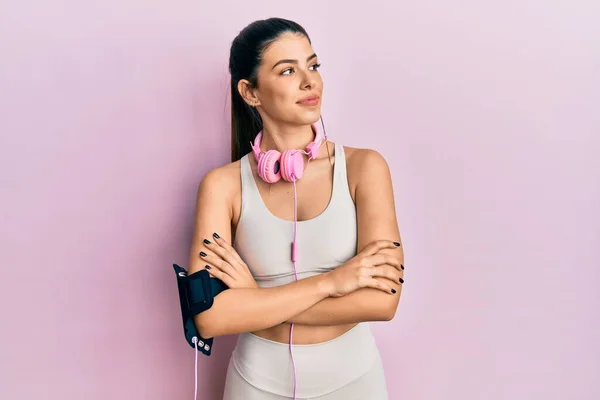 Young Hispanic Woman Wearing Gym Clothes Using Headphones Looking Side — ストック写真