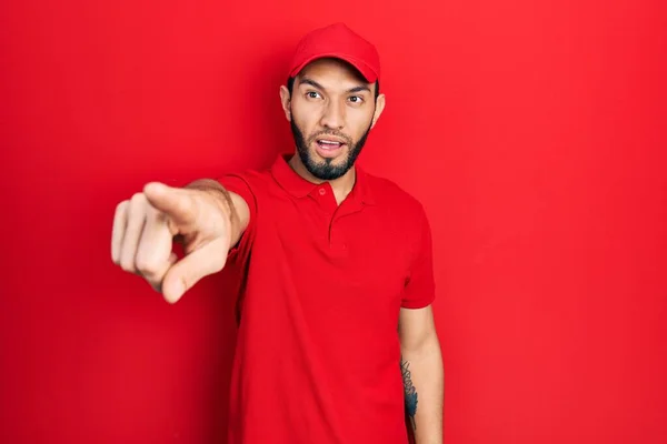 Hispanic Man Beard Wearing Delivery Uniform Cap Pointing Finger Surprised — Zdjęcie stockowe