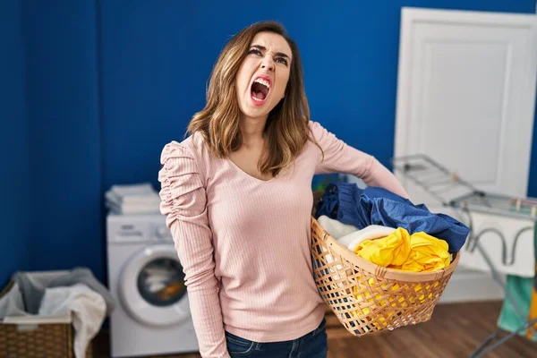 Young Woman Holding Laundry Basket Angry Mad Screaming Frustrated Furious — Stok fotoğraf