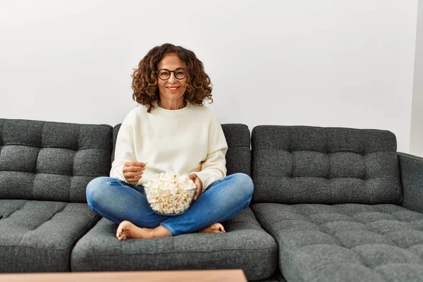 Middle age hispanic woman smiling confident watching movie at home