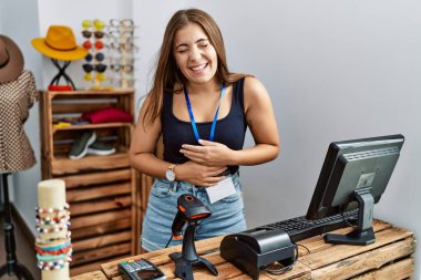 Genç esmer kadın perakende dükkanında açık mesajla pankart tutuyor. Gülümsüyor ve kahkahalarla gülüyor.. 