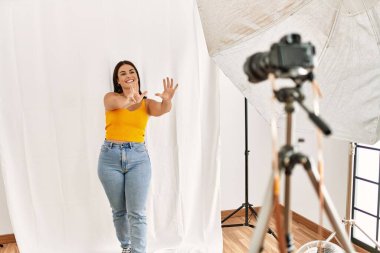 Fotoğrafçılık stüdyosunda model gibi davranan genç ve güzel bir İspanyol kadın 8 numaralı parmaklarını gösterip işaret ederken kendinden emin ve mutlu gülümsüyor.. 