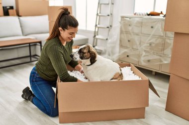 Evde köpekle oynarken kendine güvenen genç bir kadın.