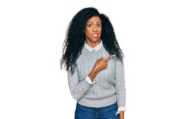 Orta yaşlı Afro-Amerikalı kadın günlük giysiler içinde endişeli ve endişeli bir şekilde işaret ediyor. 