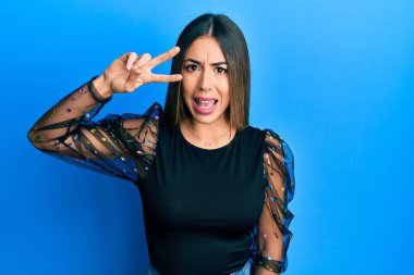 Genç İspanyol kadın zafer mimiği ile parmakları şok olmuş, şüpheci ve alaycı görünüyor, ağzı açık kalınca şaşırıyor. 