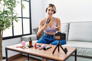 Kafkasyalı genç bir kız evdeki kanepede oturmuş demir saç dersi veriyor..