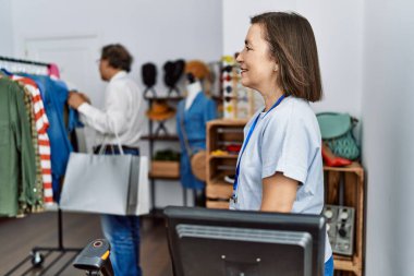 Orta yaşlı İspanyol bir kadın perakende mağazasında yönetici olarak çalışıyor. Taraf arıyor, rahat profil pozu veriyor, kendine güvenen bir gülümsemesi var.. 
