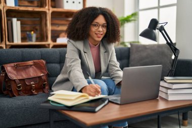 Genç Afrikalı Amerikalı kadın psikolog psikoloji merkezinde dizüstü bilgisayar kullanıyor.