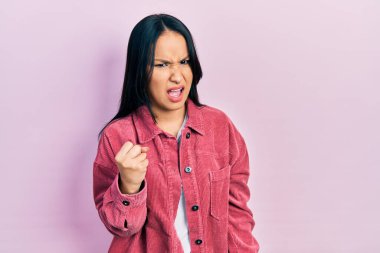 Burnuna piercing takan güzel İspanyol kadın öfkeyle bağırırken kızgın ve kızgın bir şekilde yumruk kaldırıyor. öfke ve agresif konsept. 