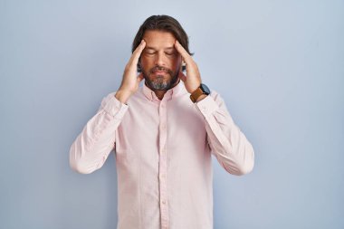 Handsome middle age man wearing elegant shirt background with hand on head, headache because stress. suffering migraine. 