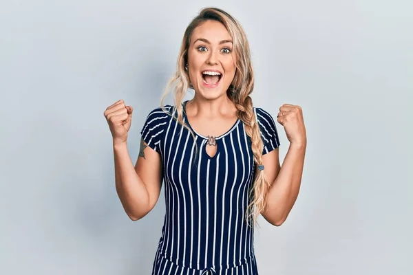 Beautiful Young Blonde Woman Wearing Casual Striped Dress Celebrating Surprised — Stock fotografie