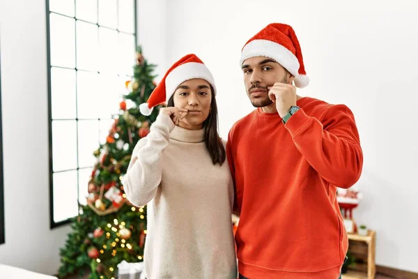Young Hispanic Couple Standing Christmas Tree Mouth Lips Shut Zip — Zdjęcie stockowe