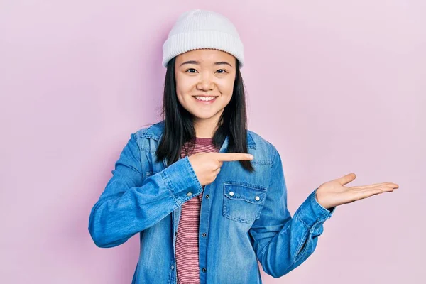 Young Chinese Girl Wearing Cute Wool Cap Amazed Smiling Camera — Stockfoto
