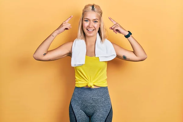 Vacker Blond Sport Kvinna Bär Träningskläder Ler Pekar Mot Huvudet — Stockfoto