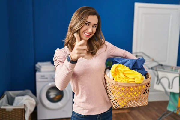 Young Woman Holding Laundry Basket Pointing Fingers Camera Happy Funny — Stockfoto