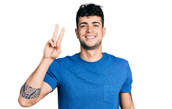 Gündelik Tişört Giyen Genç Spanyol Adam Kameraya Bakıp Zafer Işareti — Stok fotoğraf