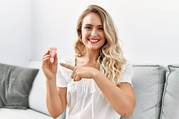 Blonde Young Woman Holding Menstrual Cup Smiling Happy Pointing Hand — Stock fotografie