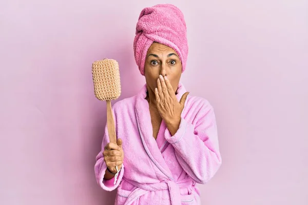 Middle Age Hispanic Woman Wearing Bathrobe Holding Sponge Covering Mouth — 스톡 사진