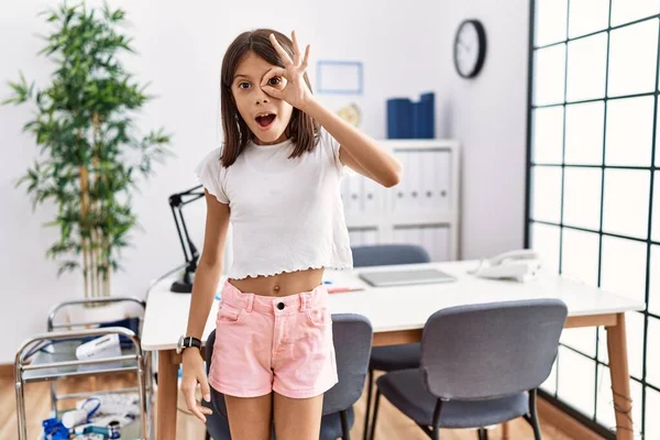 Young Hispanic Girl Standing Pediatrician Clinic Doing Gesture Shocked Surprised — Stock fotografie